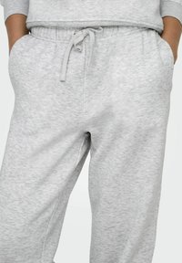 Lichtgrijze katoenen joggingbroek met een elastische tailleband en verstelbaar trekkoord. Bevat zijzakken en zachte, gestructureerde stof.
