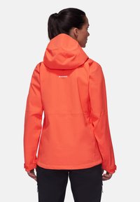 Veste imperméable orange vif avec capuche, poignets réglables et logo dans le dos. Elle présente un tissu lisse et léger.