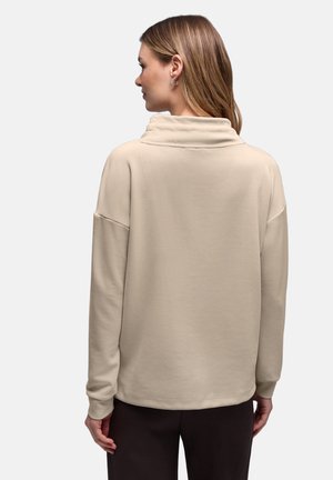Beżowa bluza z golfem, długimi rękawami, luźnym krojem i gładką fakturą, z opadającymi ramionami i prostym dołem.