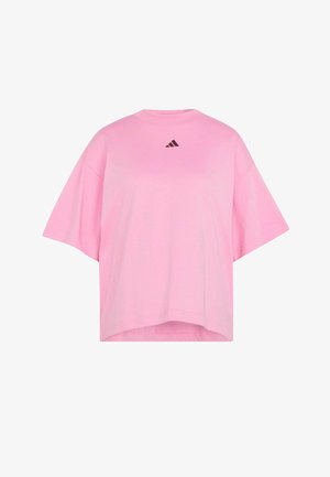 Camiseta rosa de gran tamaño hecha de tela suave. Cuello redondo, mangas cortas y cuenta con un logo negro de Adidas en el pecho. Diseño sencillo.