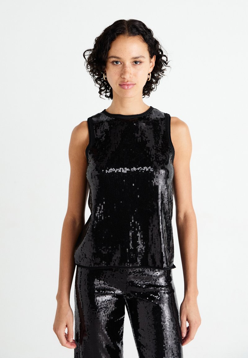 Top sin mangas de lentejuelas negras con escote redondo, que presenta una textura suave y un diseño entallado, combinado con pantalones de lentejuelas a juego.