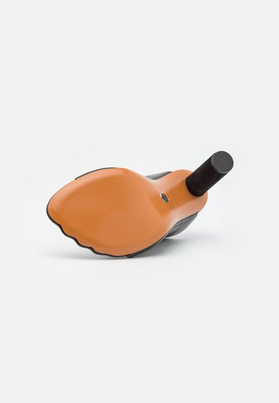 Skórzana botka na obcasie leżąca na boku, ukazująca gładką, tanową podeszwę z falistym brzegiem oraz cylindryczny czarny obcas.