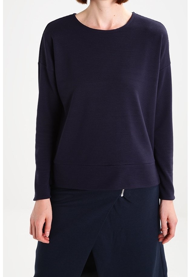 Top de manga larga navy con neckline redondo, tejido texturizado, hombros caídos y dobladillo recto. Combinado con una falda navy.