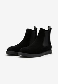 Svarta mocka Chelsea-boots med elastiska sidopaneler och en dragflik, med en rund tå och en gummisula för bättre grepp.