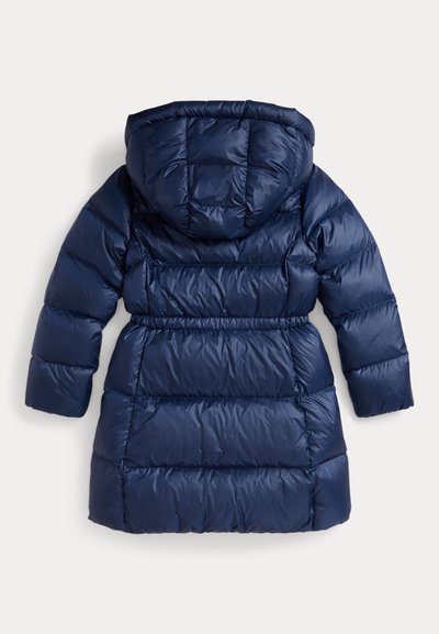Manteau d'hiver long matelassé bleu marine avec capuche, taille élastique et coutures horizontales sur un fond clair.