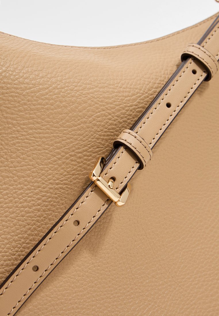 Bolso de mano de cuero color marrón claro con una superficie texturizada, que cuenta con una correa delgada ajustable con una hebilla dorada y acentos de costura oscura.