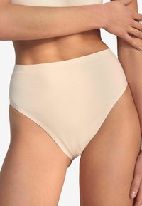 High-waisted nude bikini onderkant met een zachte textuur, naadloos ontwerp en gebogen beenopeningen voor een comfortabele pasvorm.