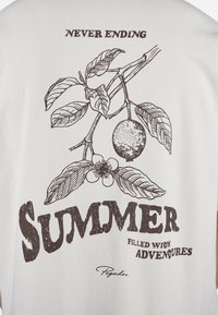 Tricou alb cu imprimeu botanic maro de frunze și fructe citrice. Textul spune "VARA FĂRĂ SFÂRȘIT PLINĂ DE AVENTURI." Include logo-ul brandului.