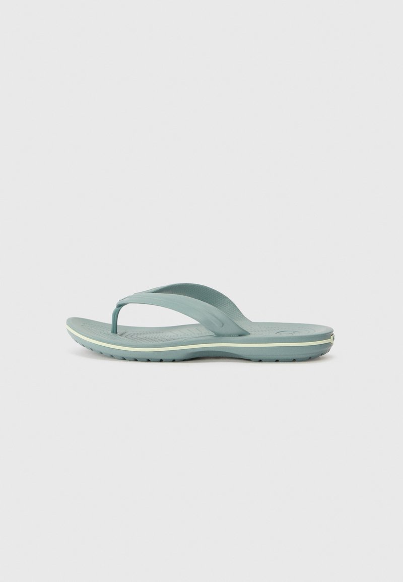 Turkoosi flip-flop-sandaalit, jotka on valmistettu kumista. Niissä on teksturoitu pohja, ohuet hihnat ja kaareva pohja, jossa on vaaleankeltainen yksityiskohta.