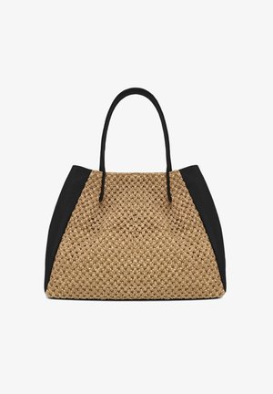 Sac fourre-tout beige tissé avec des panneaux latéraux en cuir noir et deux poignées noires sur fond blanc.