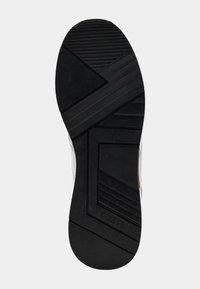 Must musta sneakeri taldil on musta kummist, tekstureeritud muster, millel on diagonaalsed sooned ja lame kulumisdisain. Kuulub "GUESS" brändile, mille logo on reljeefselt kujutatud.