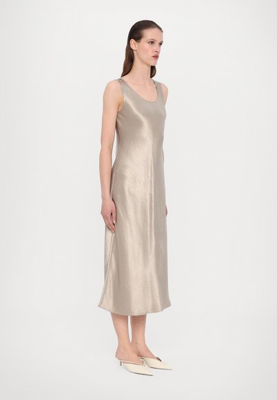 Satin midi-kjole i lys beige, med scoop-hals, tynne stropper og en glatt tekstur. Kombinert med spisse mules.