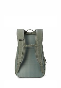 Zaino verde con spallacci imbottiti, una maniglia superiore e una fibbia sul petto regolabile. Presenta una texture liscia e un design minimalista.