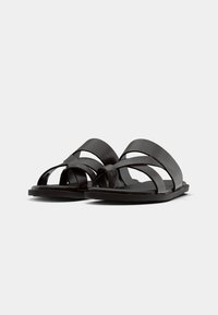 Black leather sandals with multiple wide straps, open toe design, flat sole, and a minimalist construction. No additional embellishments.