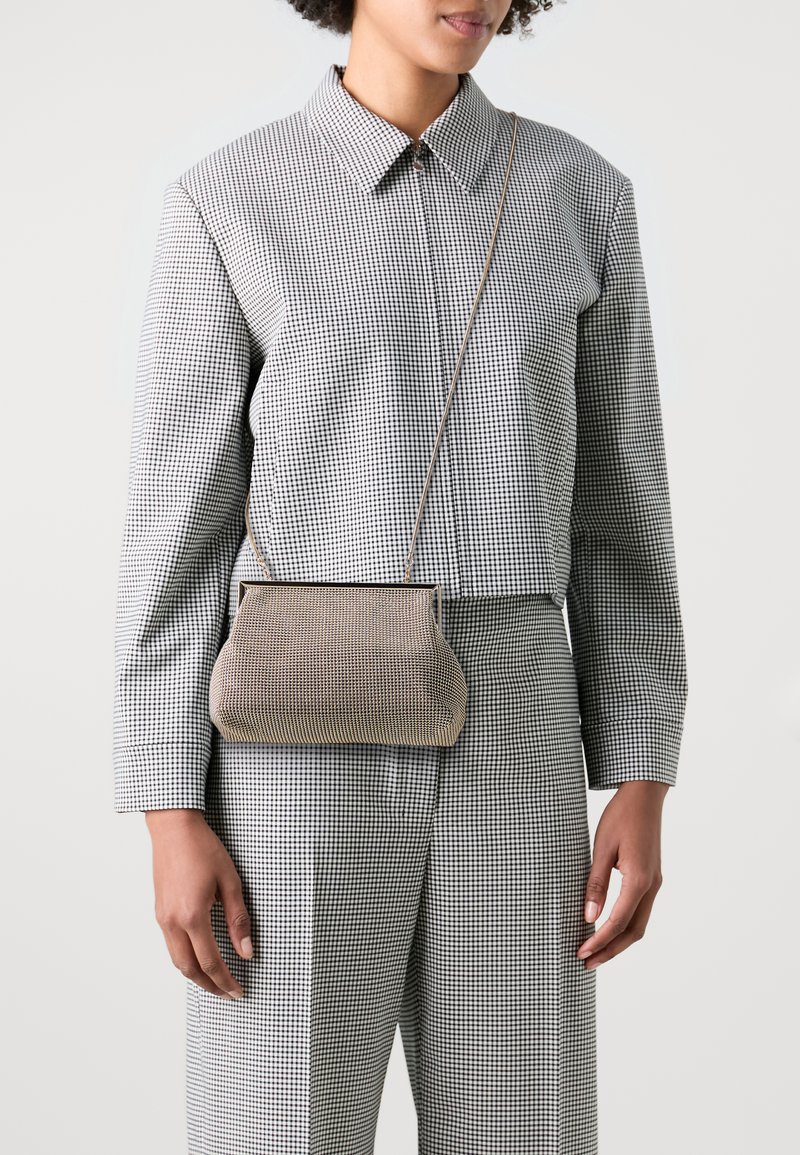 Torebka crossbody o uporządkowanym kształcie, pleciony materiał w beżowo-czarną kratę, z górną ramą i cienkim paskiem na ramię.