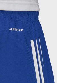 Modré sportovní šortky s texturovaným povrchem, zdobené bílými pruhy a logem "AEROREADY" na pásku pro řízení vlhkosti.