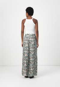 Pantaloni larghi a vita alta con un motivo floreale in beige, teal e nero. Realizzati in un tessuto leggero, presentano un design con gamba larga.
