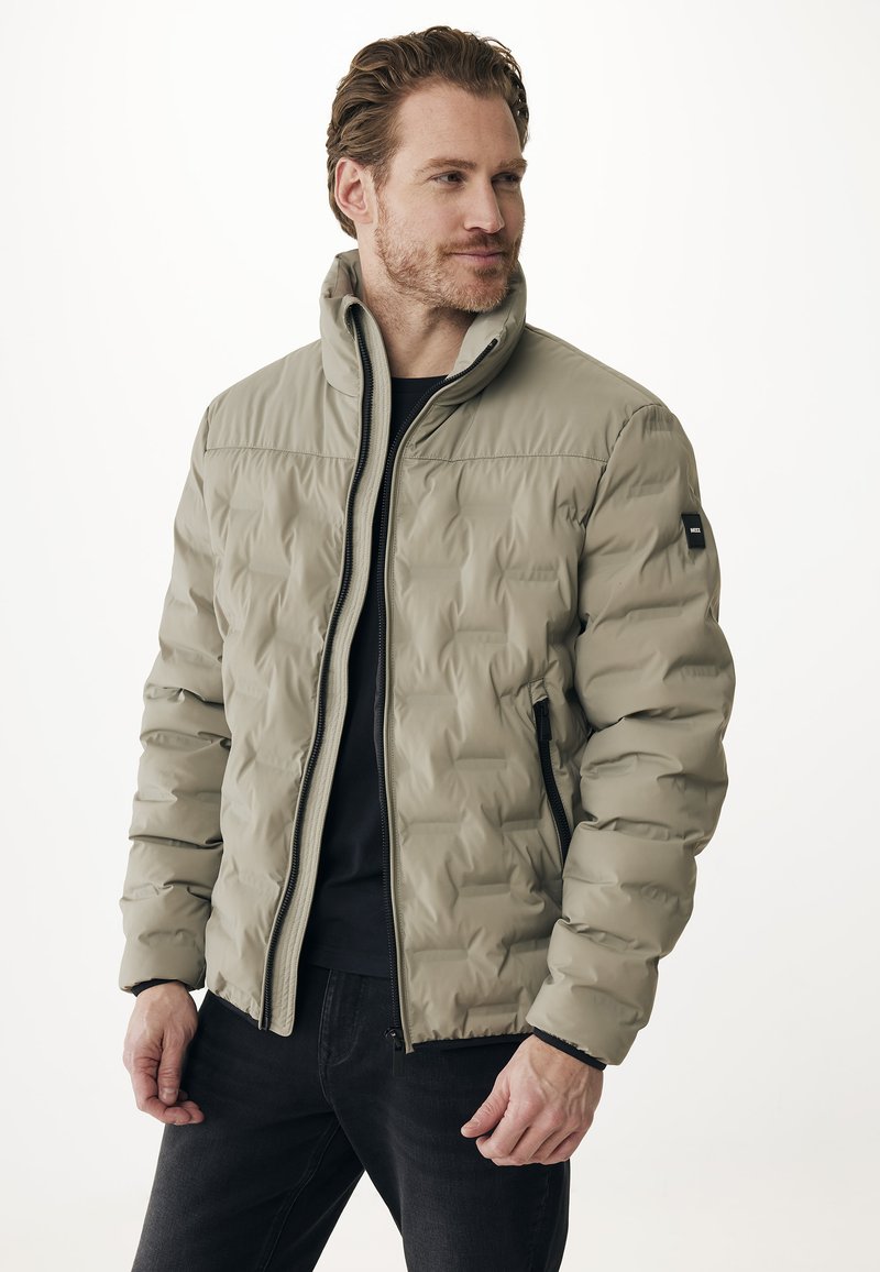 Giacca imbottita beige chiaro con colletto alto, chiusura con zip e due tasche laterali. Tessuto liscio e sottile motivo geometrico.