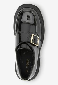 Scarpa in pelle verniciata nera con punta quadrata, singolo cinturino con fibbia in tono oro e soletta con motivo a stelle. Suola piatta nera. Taglia 12.