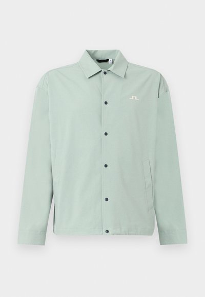 Ελαφρώς πράσινο καθημερινό μπουφάν με γιακά, μαύρα κουμπιά τύπου snap μπροστά, πλαϊνές τσέπες και μικρό λευκό κεντημένο λογότυπο στο στήθος.