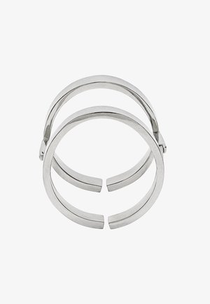 Srebrna bransoleta podwójna ze stali nierdzewnej o gładkich, zaokrąglonych krawędziach i otwartych końcach, podkreślająca minimalistyczny design i eleganckie wykończenie.