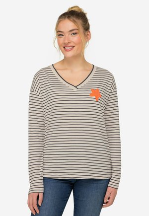 Camicia a maniche lunghe color beige chiaro con righe orizzontali blu navy e scollatura a V. Presenta un ricamo a forma di stella arancione sul petto.