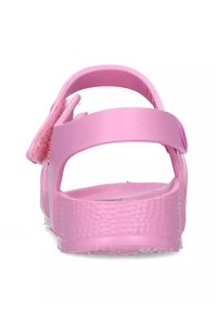 Sandalo rosa con tomaia testurizzata, cinturino posteriore regolabile e suola piatta. Realizzato in materiale gommoso, con chiusura in Velcro.