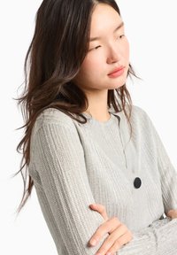 Cardigan a coste di colore grigio chiaro con scollo a V e dettaglio dei bottoni neri. Presenta maniche lunghe e un design a maglia testurizzato.