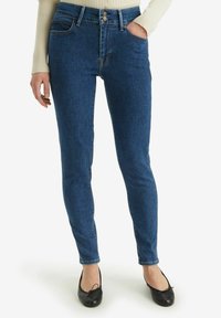 Pantalones vaqueros de mezclilla azul oscuro con un diseño de cintura alta, que presentan un estilo de cinco bolsillos, pasadores para cinturón y un cierre de dos botones. Textura suave.