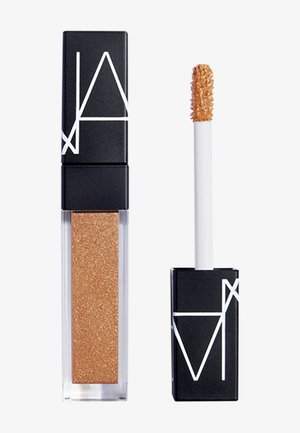 Glanzende gouden vloeibare lipgloss met zwarte rechthoekige dop en wit geometrisch logo, getoond met applicatorstok naast de container.