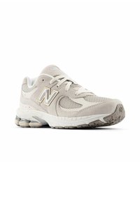 Light beige sneaker with mesh and suede panels, notable "N" logo, rounded toe, thick white sole, and textured grip outsole.