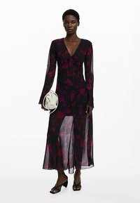 Lang, doorschijnend jurkje met een bloemenpatroon in donkerroze en bordeauxrood, met lange mouwen, een V-hals en een strikdetail aan de voorkant.