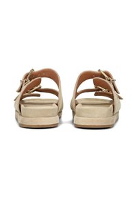 Beige suède sandalen met dubbele verstelbare banden, open achterkant en een platte, textuurgegeven zool. Voorzien van gouden accenten.