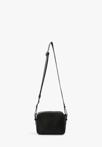 Bolso cruzado de cuero negro con forma rectangular, superficie texturizada, correa ajustable y cierre de cremallera. Presenta un diseño minimalista.