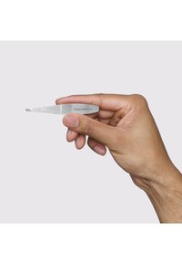 Mano che tiene una pinzetta Tweezerman in acciaio inossidabile con punta inclinata su uno sfondo chiaro semplice.