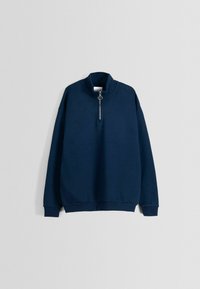 Sudadera azul marino con cuello alto, media cremallera con un tirador circular y puños y dobladillo acanalados. Confeccionada en tela suave.