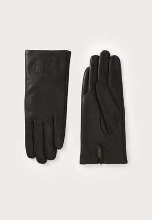 Sorte skinnhansker med en jevn tekstur, med sydde detaljer og et preget 'CK'-logo. Inkluderer en liten åpning ved håndleddet.
