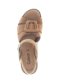 Brown suede sandal with a wide strap design, featuring a large decorative buckle, cushioned insole, and textured rubber outsole.