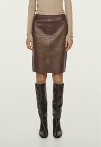 Jupe crayon en cuir marron avec un motif crocodile texturé, longueur genou, avec une finition lisse et une couture centrale à l'arrière.