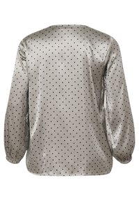 Blouse en satin gris à manches longues avec des pois noirs. Dotée d'un col rond et de poignets froncés pour une coupe décontractée. Texture lisse.