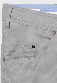 Graue Hosen mit einem strukturierten Stoff, sichtbaren Nähten, einer Vordertasche und metallischen Akzenten. Das Innere zeigt ein hellblaues Futter.
