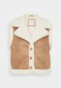 Tan faux suede väst med en krämfärgad fårskinnskrage och trim. Har fem knappar och sidofickor. Strukturerad, mysig utseende.