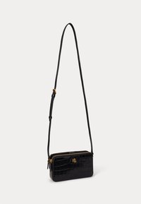 Melnas mākslīgās ādas crossbody soma ar krokodila faktūru, zelta furnitūra, taisnstūra forma un regulējama siksna. Iekļauj rāvējslēdzēja aizvēršanu.