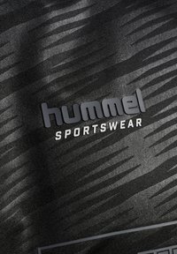 Schwarzer Sportstoff mit strukturiertem Muster, mit einem auffälligen grauen Logo, auf dem "hummel" über dem Wort "SPORTSWEAR" steht.