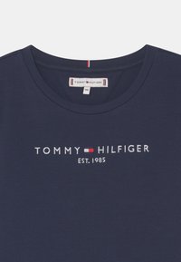 Granatowy bawełniany t-shirt z okrągłym kołnierzem, haftowanym logo "TOMMY HILFIGER" z czerwonymi i białymi akcentami oraz napisem "EST. 1985."