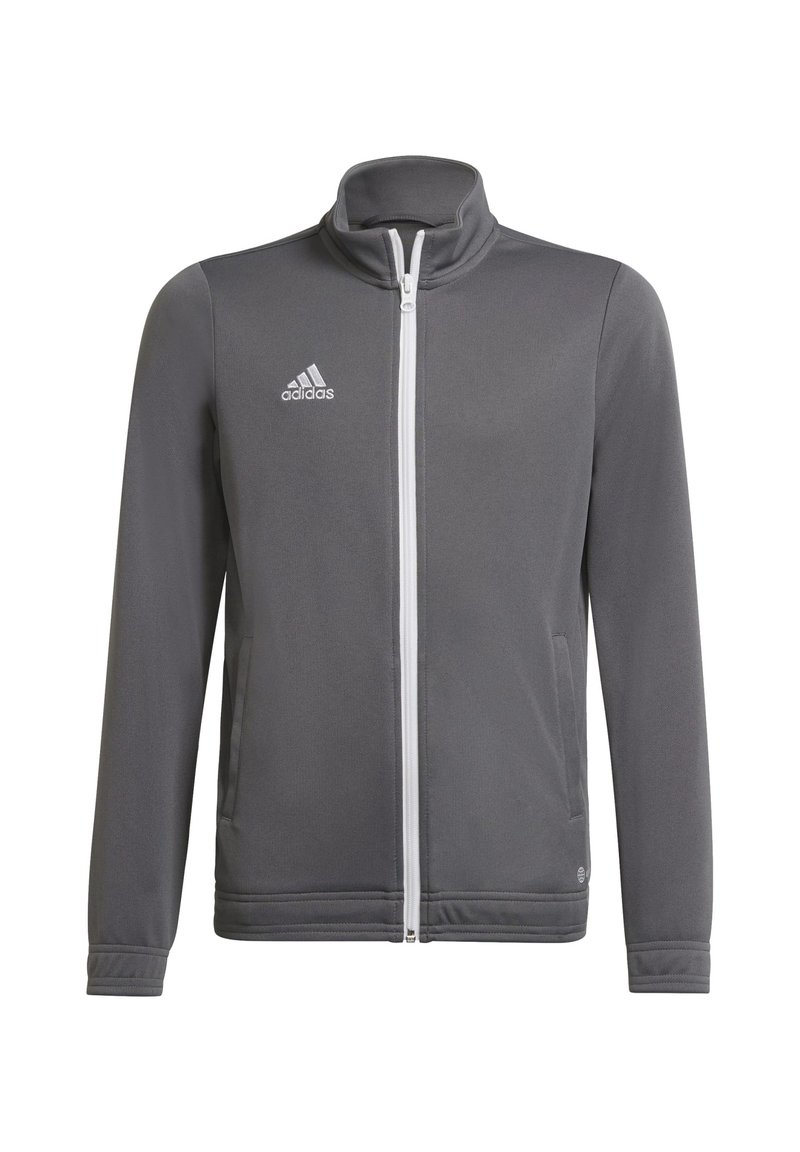 Chaqueta deportiva gris hecha de material sintético. Cuenta con un cuello alto, cremallera completa y el logo blanco de Adidas en el lado izquierdo del pecho.