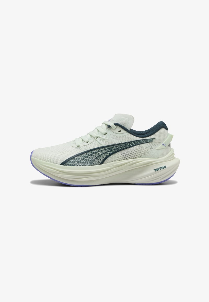 Witte hardloopschoenen met een bovenkant van mesh, groene accenten en een dikke zool. Bevat een gestructureerde streep en een paarse buitenzool. Logo weergegeven.