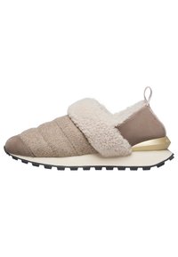 Beige slip-on sko med kviltad textur, en fluffig vit krage och en guldaccent på hälen, med en svart gummisula.