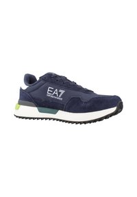 Sneaker blu navy con un mix di tessuto testurizzato e materiale liscio, con logo bianco, accenti verdi e neri e suola in gomma.