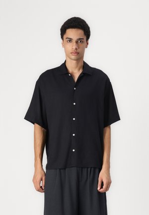 Chemise noire à manches courtes avec un devant boutonné, faite d'un tissu léger. Présente un col classique et une coupe décontractée.
